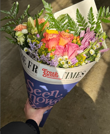 Fresh Sends sympathy bouquet with bright mixed blooms wrapped in vintage newspaper-style paper.-317283926383