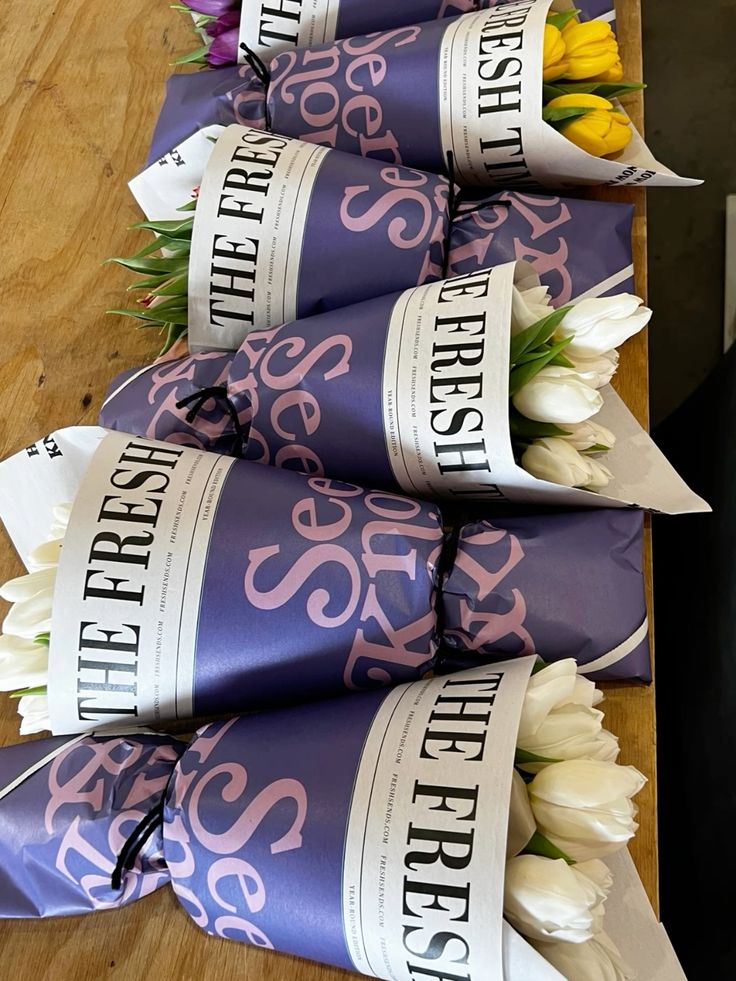 White tulips wrapped in Fresh Sends’ newspaper-style packaging for a simple and elegant sympathy bouquet.-320230785391