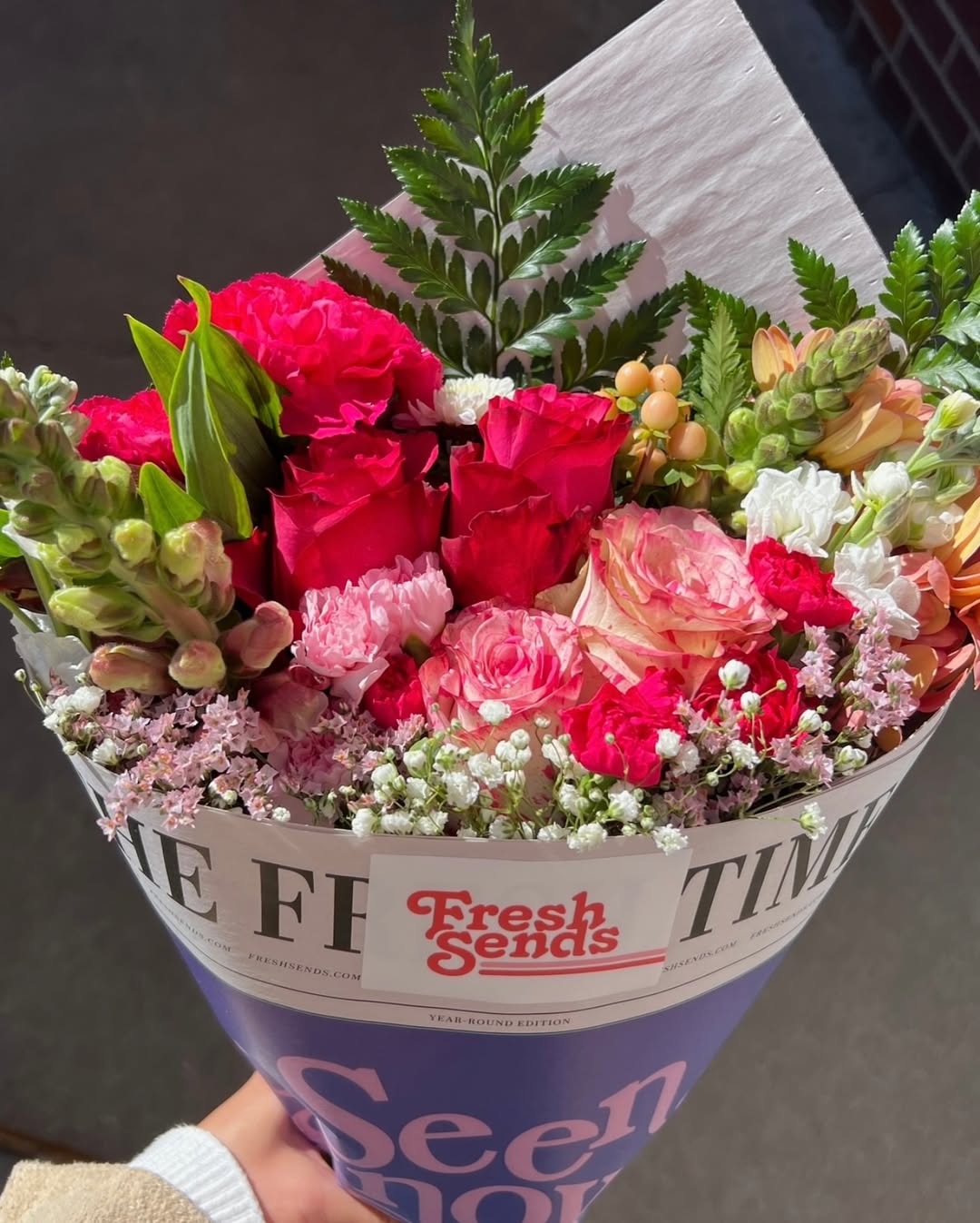 Pink Fresh Sends bouquet with roses, carnations, and lush greenery wrapped in eco friendly newspaper paper.-320436371823