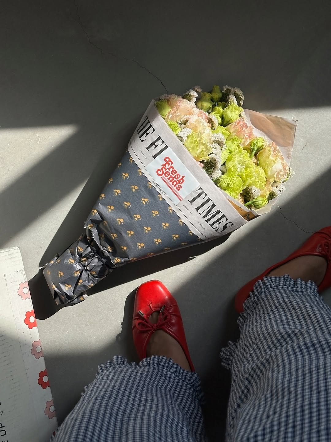 A woman with just legs visible stands in front of a bouquet of fresh flowers delivered by Fresh Sends.-319854772591