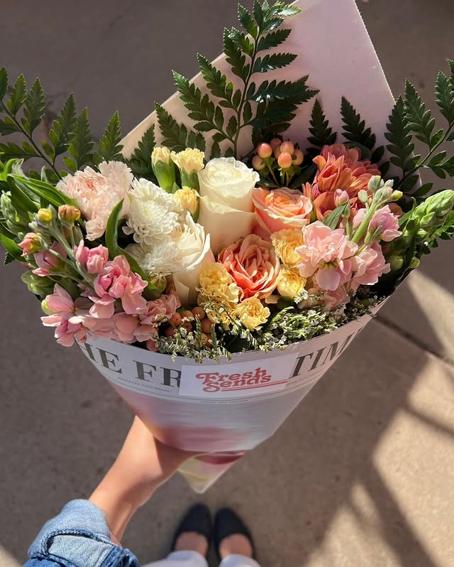 Hand holding a Fresh Sends bouquet with seasonal blooms, perfect for Mother’s Day gifting.-319053660527
