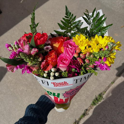 A hand holding a Fresh Sends bouquet filled with vibrant and colorful flowers.-317718888815