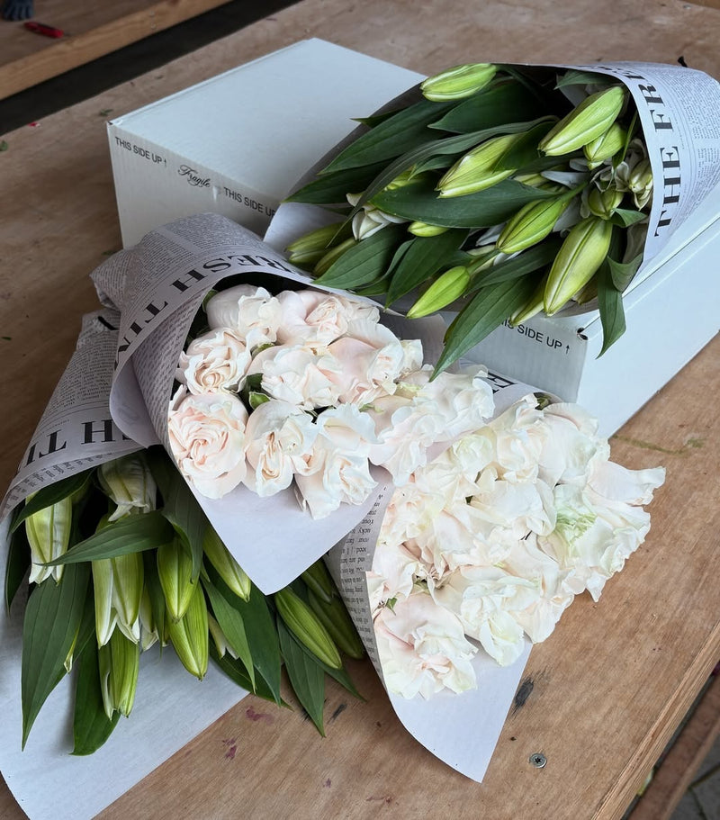 Fresh Sends bouquets of white roses and lilies ready for a condolence delivery.