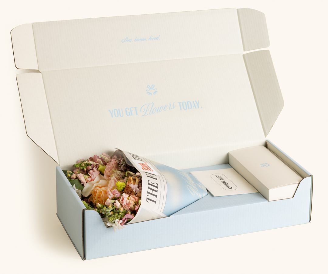 Customer photographing a Fresh Sends flower arrangement with premium wrapping and gift-ready presentation.
