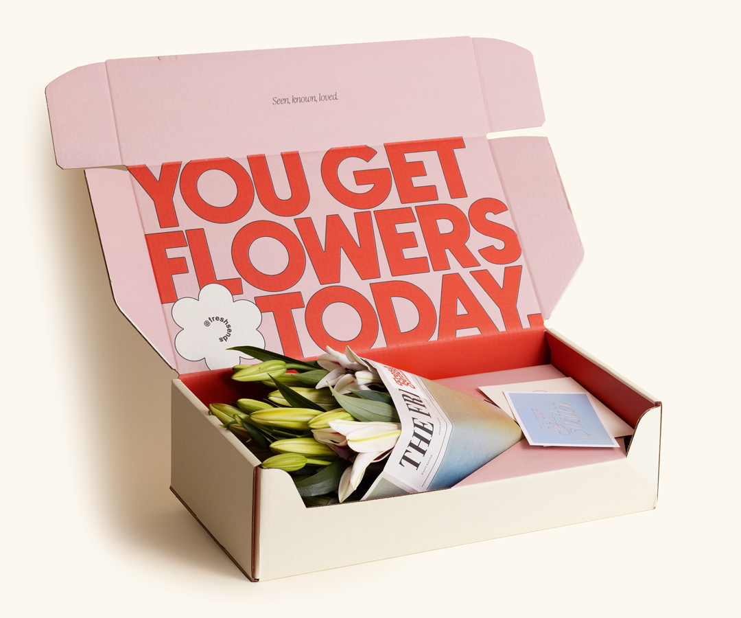 A Fresh Sends Easter lily bouquet wrapped in signature paper, placed inside a box with a